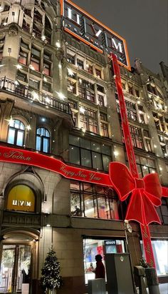 a very tall building with a giant red bow on it's front door and windows