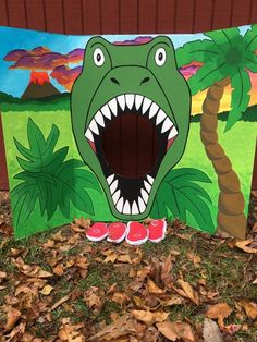 a cardboard cutout of a dinosaur with its mouth open and teeth wide open, in front of a background of palm trees