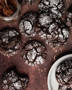 chocolate crinkle cookies with powdered sugar in the middle on a brown table