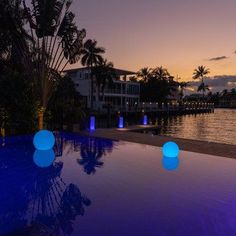 the lights are glowing in the water by the dock