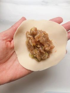 a person is holding an uncooked piece of food in their hand