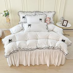 a bed with white sheets and black bows on it