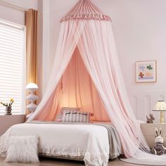 a pink canopy bed in a girls bedroom