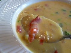 a spoon full of soup on top of a white plate