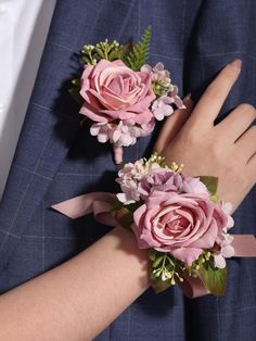 two pink roses are tied to the lapel of a man in a blue suit