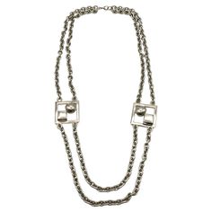 PACO RABANNE vintage silver tone double chain necklace featuring two large 3-dimensional modernist square links. Lobster clasp closure. Embossed PACO RABANNE. Indicative measurements : length approx. 80.5 cm (31.69 inches) / modernist square links approx. 3.7 x 3.7 cm (1.46 inches x 1.46 inches). Material : Silver tone metal hardware. NOTES - This is a preloved vintage item, therefore it might have imperfections. - Colors may differ slightly from actual product appearance due to differences in l Formal Double Strand Metal Chain Necklace, Silver Metal Chain Necklace With Rectangular Links, Vintage Silver Jewelry With Double Chain, Formal Metal Chain Necklace With Rectangular Links, Modern Necklaces With Rectangular Silver Chain, Modern Necklace With Rectangular Silver Chain, Rectangular Chunky Chain Metal Necklace, Modern Silver Double Chain Necklace, Modern Silver Rectangular Necklaces