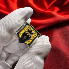 a close up of a person's hand wearing a white glove with a yellow and black emblem on it