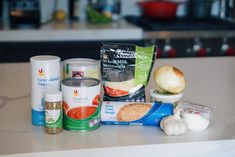 an assortment of food items sitting on top of a counter next to cans and containers