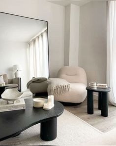 a living room filled with furniture and a large mirror over the top of a coffee table