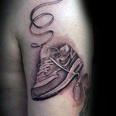 a tattoo on the arm of a man with a sneaker and shoe in it