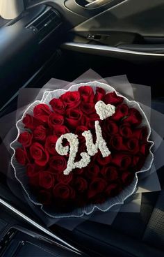 a bouquet of red roses sitting on top of a car dash board with the number 9