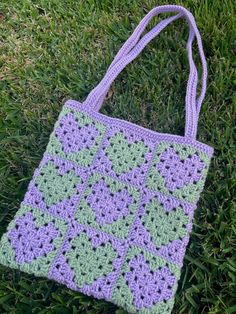 a crocheted bag laying on the grass