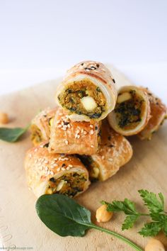 several rolls are stacked on top of each other with cheese and herbs in the middle