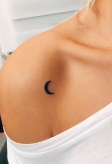 a woman with a crescent tattoo on her stomach