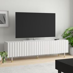 a flat screen tv mounted to the side of a white cabinet in a living room