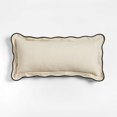 a white and black pillow on a white wall