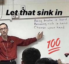 a man standing in front of a whiteboard with writing on it and people sitting around him