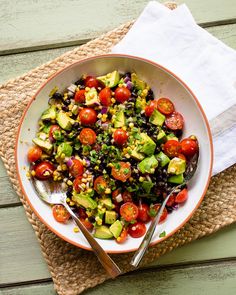 a salad with tomatoes, avocado, corn and black beans in a bowl