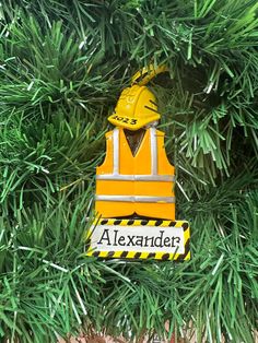 an ornament hanging from a christmas tree in the shape of a construction worker's vest