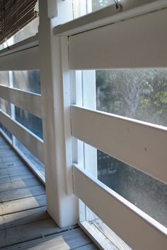 an open window on the side of a building with wood flooring and white trim