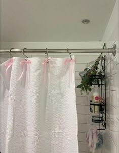 a shower curtain with pink bows hanging from it's side in a bathroom next to a toilet