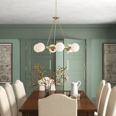 a dining room table with white chairs around it