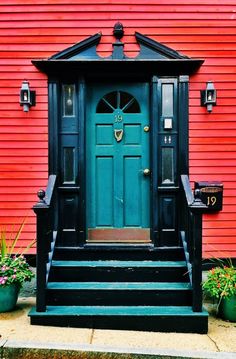 a green door is in front of a red building