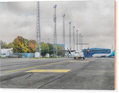 an airplane is parked on the tarmac in front of some power lines and towers