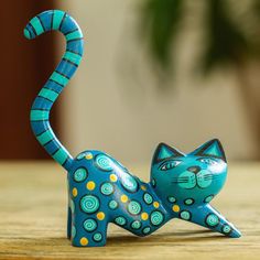 a blue cat figurine sitting on top of a wooden table