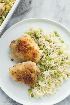 two pieces of chicken with rice and peas on a plate