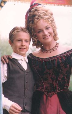 a young boy and woman are posing for a photo