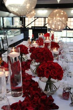 a table is set with red roses and candles