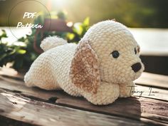 a white stuffed dog laying on top of a wooden table