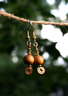 These simple dangle earrings are made from wooden beads on a copper wire scroll. I like the primitive feel. They 1.25 inches long. Surgical steel hooks. Wooden Earrings Diy, Brown Copper Bead Earrings, Wooden Beads Drop Earrings, Brown Copper Earrings With Round Beads, Brown Copper Beaded Dangling Earrings, Brown Adjustable Copper Wire Earrings, Brown Wooden Bead Earrings, Vintage Brown Earrings With Dangling Beads, Brown Wooden Dangle Jewelry