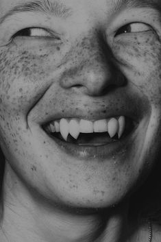 a black and white photo of a man with freckles on his face smiling