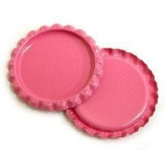 two pink bottle caps sitting on top of each other