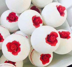 some white and red donuts with rose decorations on them