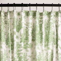 green and white curtains hanging from a metal rod