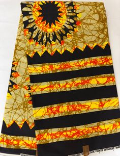 two yellow and black scarves with an orange sunflower on the top one is made out of fabric