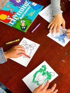 two children drawing pictures on paper with crayons