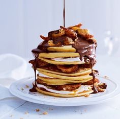 a stack of pancakes with chocolate drizzled on top