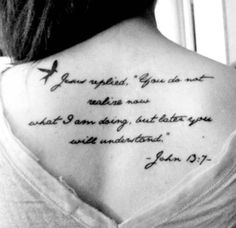 the back of a woman's neck with a quote from john 3 19 on it