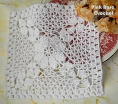 two white crocheted doily sitting on top of a red and white plate