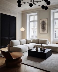 a living room filled with white furniture and large windows next to a wooden flooring