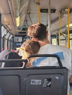 two people sitting on a bus with their backs to each other