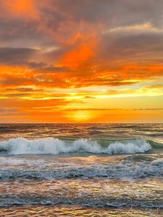 an orange and yellow sunset over the ocean