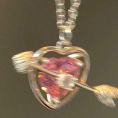 a heart shaped pendant is hanging from a chain