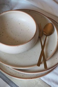 a white plate topped with two gold colored spoons