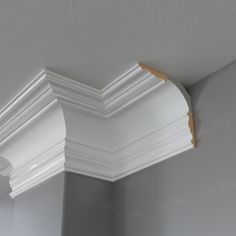 the corner of a room with white molding on the walls and ceiling above it