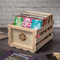 a wooden box filled with cd's on top of a table